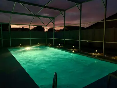 a large swimming pool at night with a tent at Amazing Blue Private Pool 4BR House Near Disney in Kissimmee