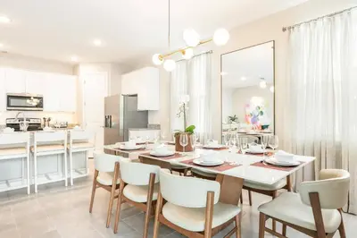 a kitchen and dining room with a table and chairs at 7992 Cozy 5BD Disney Getaway with Pool in Orlando