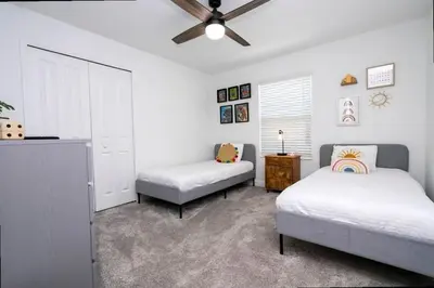 a bedroom with two beds and a ceiling fan at Splendid 5Bd Close to Disney at Storey Lake 4251 in Kissimmee