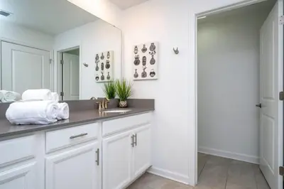 a white bathroom with a sink and a mirror at Gorgeous 4 Bd w Pool at Storey Lake Resort 4277 in Kissimmee