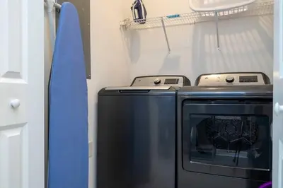 a kitchen with a washing machine and a surfboard at Gorgeous 4 Bd w Pool at Storey Lake Resort 4277 in Kissimmee