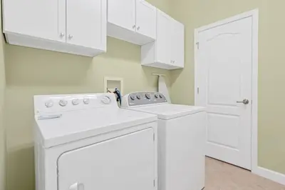 a white washer and dryer in a laundry room at Near Disney - 5BR Home- Games Pool Hot Tub & BBQ in Kissimmee