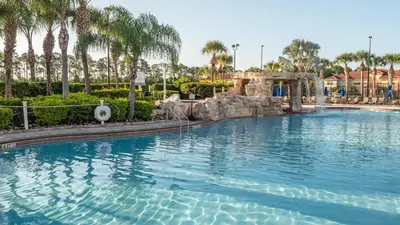 a swimming pool in a resort with palm trees at Near Disney - 5BR Home- Games Pool Hot Tub & BBQ in Kissimmee