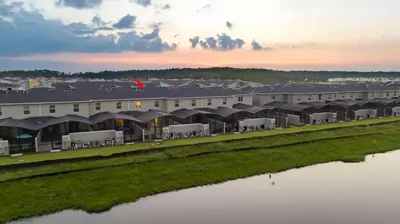 a large building next to a body of water at Marvelous 4Bd w Pool Close to Disney at Storey Lake 2629 in Kissimmee