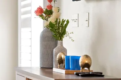 two vases sitting on top of a table with flowers at Private Oasis in Kissimmee - Pool, BBQ, Free Parking in Orlando