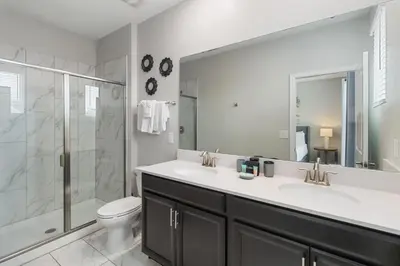 a bathroom with two sinks and a shower and a toilet at Storey Lake Resort, Private Pool, And Much More!! in Kissimmee