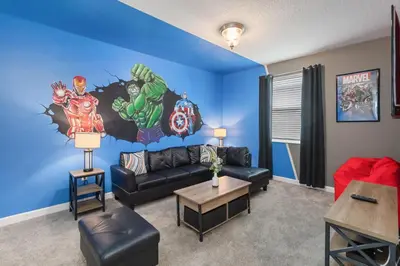a living room with a marvel mural on the wall at Storey Lake Resort, Private Pool, And Much More!! in Kissimmee
