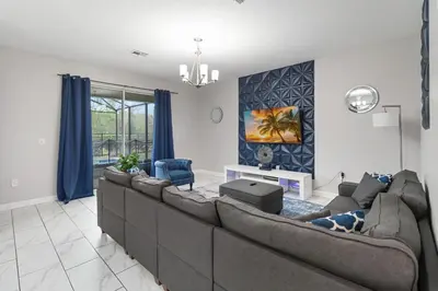 a living room with a large couch and blue curtains at Storey Lake Resort, Private Pool, And Much More!! in Kissimmee
