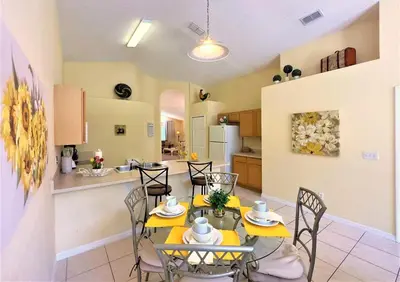 a dining room and kitchen with a table and chairs at Restful 4BR 3BA with BBQ, Heated Pool & SPA in Kissimmee