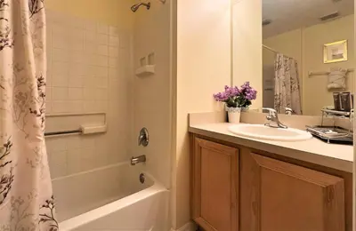 a bathroom with a tub and a sink and a shower at Restful 4BR 3BA with BBQ, Heated Pool & SPA in Kissimmee