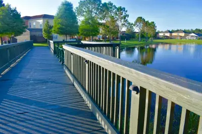 a wooden bridge over a body of water at Restful 4BR 3BA with BBQ, Heated Pool & SPA in Kissimmee