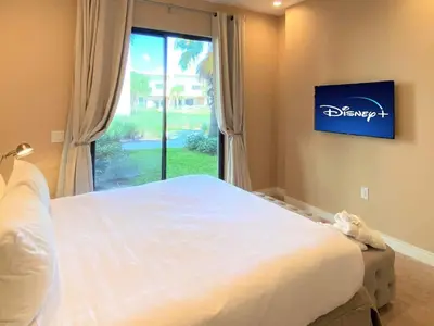 a bedroom with a large bed and a window at Family Home w BBQ, 7 Min from Disney, Accessible in Orlando