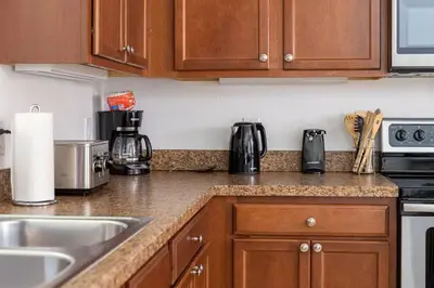 a kitchen with wooden cabinets and a counter top at 558 - Veranda Palms House in Kissimmee