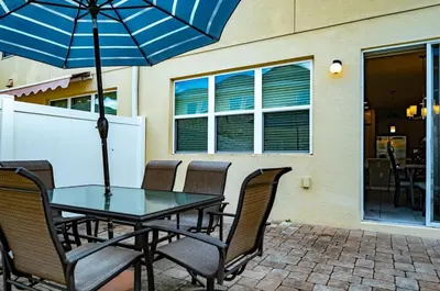 a table with chairs and an umbrella on a patio at Vacation Home for 8, near Disney and Universal in Kissimmee