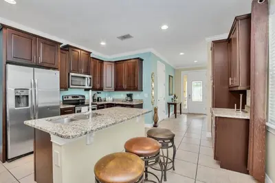 a kitchen with wooden cabinets and a counter top at 450 Paradise 8BD Villa- Game Room PoolSpa in Orlando