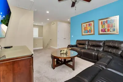 a living room with a leather couch and a table at 450 Paradise 8BD Villa- Game Room PoolSpa in Orlando