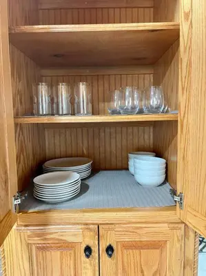 a wooden cabinet with plates and bowls and glasses at Peaceful Home in Central Florida Near Universal in Orlando