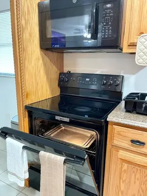 a kitchen with a black stove and a microwave at Peaceful Home in Central Florida Near Universal in Orlando