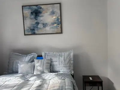 a bed with white pillows and a picture on the wall at Peaceful Home in Central Florida Near Universal in Orlando