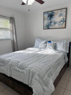 a bedroom with a large bed with a striped comforter at Peaceful Home in Central Florida Near Universal in Orlando