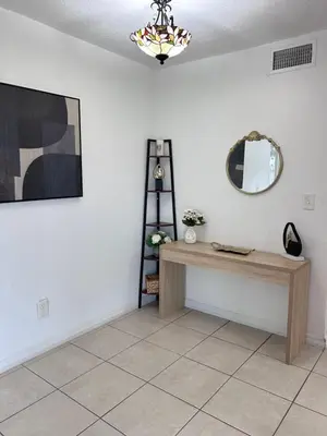 a room with a table and a mirror on a wall at Peaceful Home in Central Florida Near Universal in Orlando