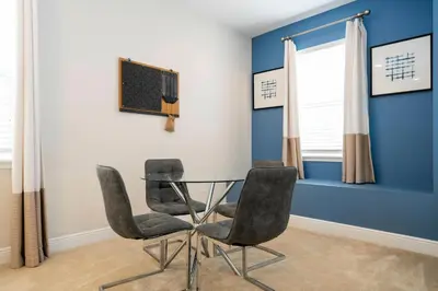 a dining room with a glass table and two chairs at Unforgettable Experience Luxury Vacation Home 7479 in Orlando