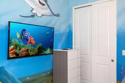 a room with a tv with a dolphin and a fish on the wall at Unforgettable Experience Luxury Vacation Home 7479 in Orlando