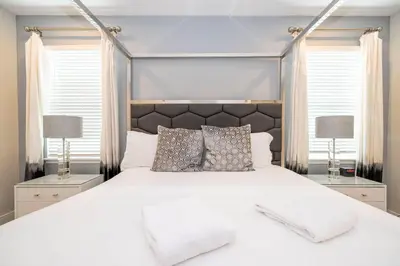 a bedroom with a large white bed with two lamps at Unforgettable Experience Luxury Vacation Home 7479 in Orlando