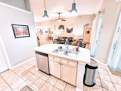 a kitchen with a sink and a living room at Family Friendly Disney Villa (4 Miles from Disney) in Kissimmee