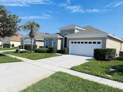a house with a driveway and a garage at Family Friendly Disney Villa (4 Miles from Disney) in Kissimmee
