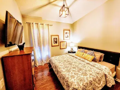 a bedroom with a bed and a dresser in it at Family Friendly Disney Villa (4 Miles from Disney) in Kissimmee
