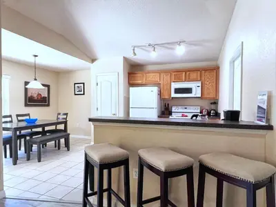 a kitchen with a bar and a table and chairs at Lovely 3-Bedroom Pool Villa-1445SCD in Orlando