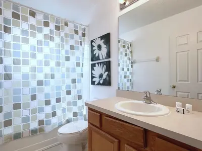 a bathroom with a sink and a toilet and a mirror at Spacious 7Bd Pool Gm Hm Terra Verde Resort-211HBL in Kissimmee