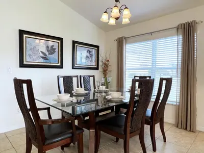 a dining room with a glass table and chairs at Cozy 4 Bed 3 Bath Pool Hm with Game Room-4450NP in Kissimmee