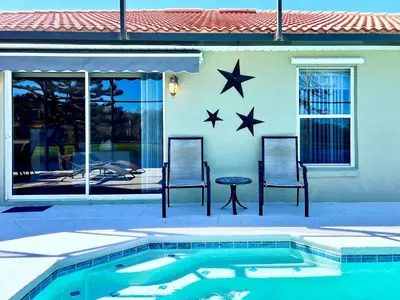 two chairs and a table with stars on the side of a house at Lovely Lakeside 4-Bed Pool Home at Villa Sol-3125 in Kissimmee
