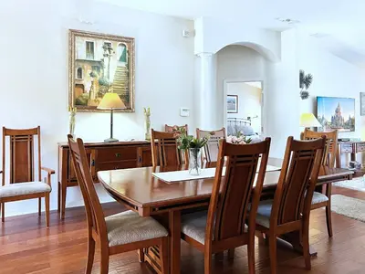 a dining room with a wooden table and chairs at Lovely Lakeside 4-Bed Pool Home at Villa Sol-3125 in Kissimmee