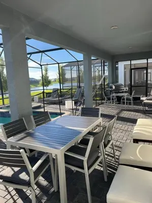a patio with a table and chairs and a pool at 33 Disney Villa GameRoom Movie Theater Pool in Kissimmee