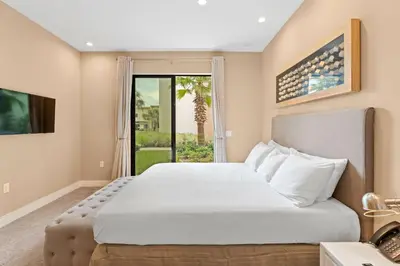 a bedroom with a large white bed and a window at 7545 Magic Village 4 suites 8 guests 8 min Disney in Orlando