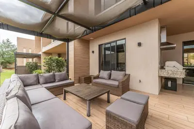 a patio with a couch and chairs and a table at 3081 Magic Village 4suites Jacuzzi Near 192 8 min Disney in Orlando