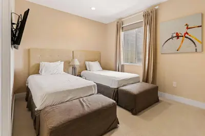 a bedroom with two beds and a bicycle on the wall at 7659 Magic Village Excellent 4 suites 6 min Disney in Orlando