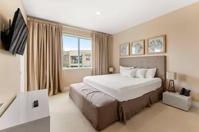 a bedroom with a large bed and a television at 7659 Magic Village Excellent 4 suites 6 min Disney in Orlando