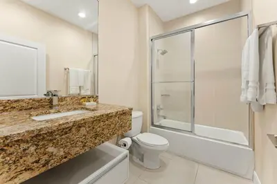 a bathroom with a sink and a toilet and a shower at 7648 Magic Village lovely 4suites 8guests 8 min Disney in Orlando