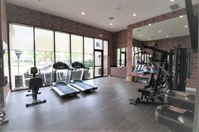 a gym with several treadmills and machines in it at 7648 Magic Village lovely 4suites 8guests 8 min Disney in Orlando