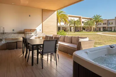 a patio with a table and chairs and a tub at 7458 Magic Village 3suites 8guests jacuzzi 8 min Disney in Orlando