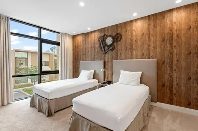 two beds in a room with wooden walls at 7589 Magic Village 8 guests 4 suites BBQ near 192 Disney in Orlando