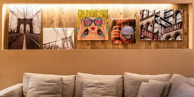 four pictures hanging on a wall above a couch at 7589 Magic Village 8 guests 4 suites BBQ near 192 Disney in Orlando