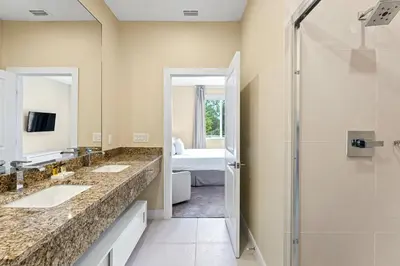 a bathroom with two sinks and a shower at 3212 Magic Village 8 guests lakefront 8 min Disney in Orlando