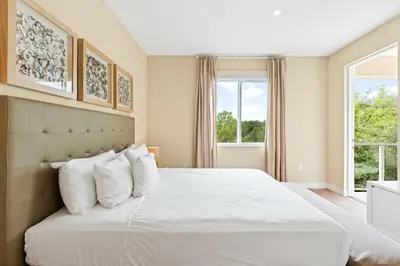 a bedroom with a large white bed with white pillows at 3212 Magic Village 8 guests lakefront 8 min Disney in Orlando