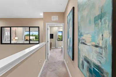 a hallway with large paintings on the walls at 7564 Magic Village 3 suites jacuzzi BBQ 8 min Disney in Orlando