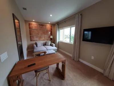 a living room with a couch and a table at 3045 Magic Village8 guests 4 suites BBQ 8 min Disney in Orlando